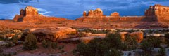 En bordure de la route principale du Needles District, entité du parc national des Canyonlands, situé en Utah, on aperçoit l'arche naturelle Wooden Shoe, dont le profil évoque un sabot de bois, situé au sommet d'un aileron de grès